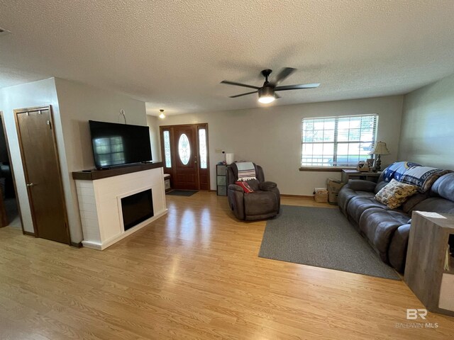 living room with a textured ceiling, a healthy amount of sunlight, and light wood-type flooring