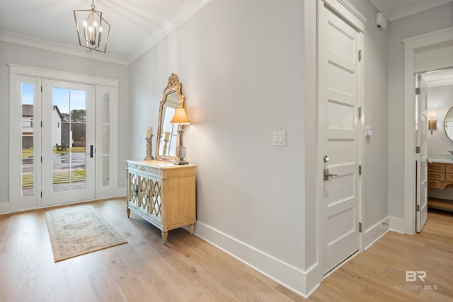 interior space featuring an inviting chandelier, ornamental molding, and light wood-type flooring