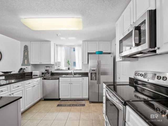 375 Beach Club Trl Unit A1710, Gulf Shores, AL 36542 - kitchen with stainless steel appliances, a textured ceiling, white cabinetry, and light tile patterned floors