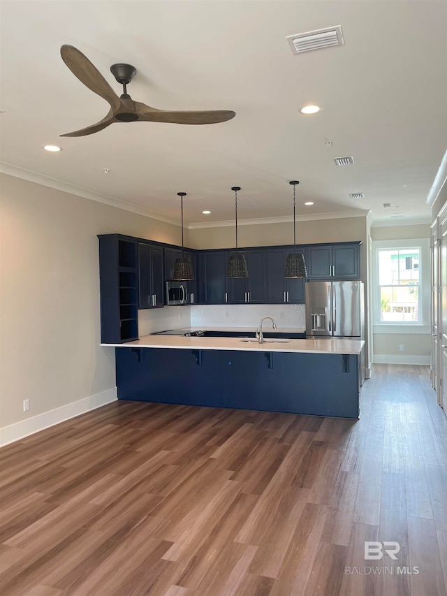 kitchen featuring a kitchen bar, stainless steel appliances, wood-type flooring, and ceiling fan