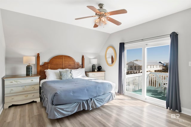 bedroom featuring light hardwood / wood-style flooring, ceiling fan, vaulted ceiling, and access to exterior