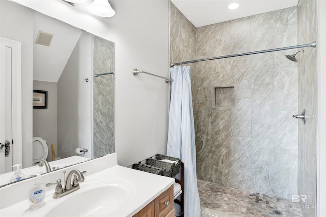 bathroom with walk in shower, oversized vanity, and toilet