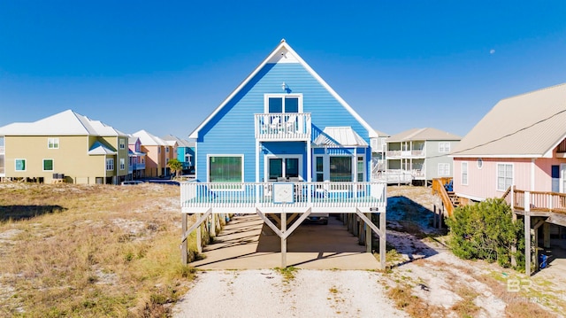 rear view of house with a balcony and a wooden deck