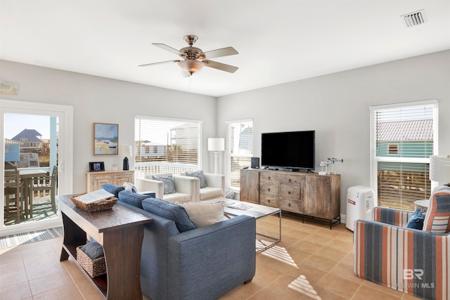 tiled living room with plenty of natural light and ceiling fan