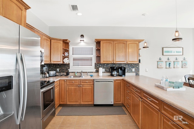 kitchen featuring appliances with stainless steel finishes, hanging light fixtures, backsplash, and light tile flooring