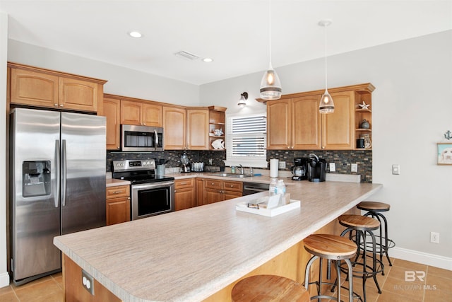 kitchen with decorative light fixtures, a breakfast bar, tasteful backsplash, and stainless steel appliances