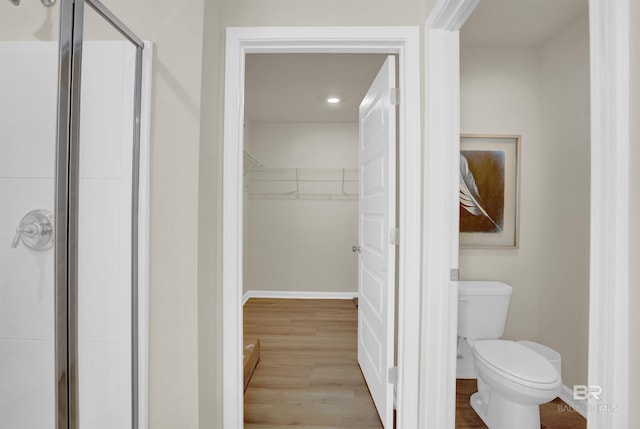 1032 Hayward Loop, Foley, AL 36535 - bathroom with a walk in closet, a shower stall, wood finished floors, and recessed lighting