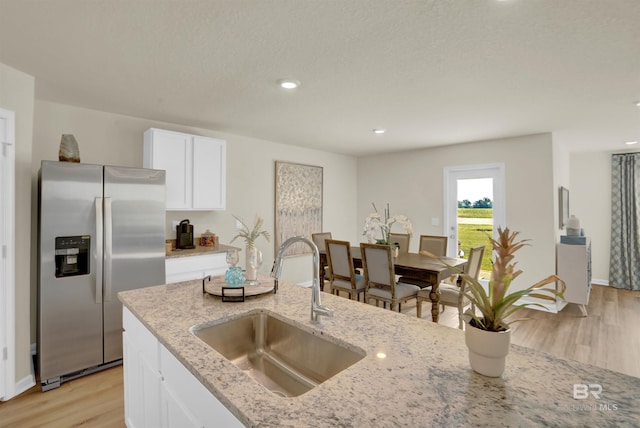 1032 Hayward Loop, Foley, AL 36535 - kitchen with stainless steel fridge with ice dispenser, light wood-style floors, light stone counters, white cabinetry, and recessed lighting