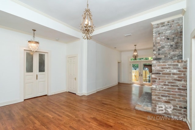 interior space featuring an inviting chandelier, hardwood / wood-style floors, ornamental molding, and french doors