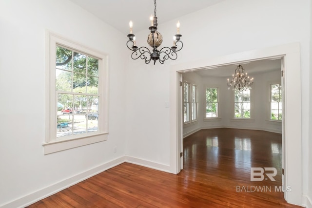 empty room featuring hardwood / wood-style floors and an inviting chandelier