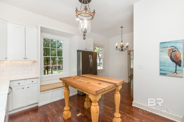 dining area with a notable chandelier and dark hardwood / wood-style floors