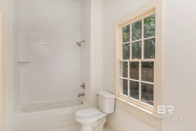 bathroom with toilet and tiled shower / bath