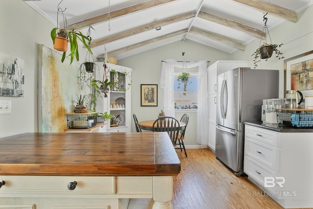 3425 Ponce De Leon Ct, Gulf Shores, AL 36542 - kitchen featuring white cabinets, dark countertops, freestanding refrigerator, vaulted ceiling with beams, and light wood-type flooring