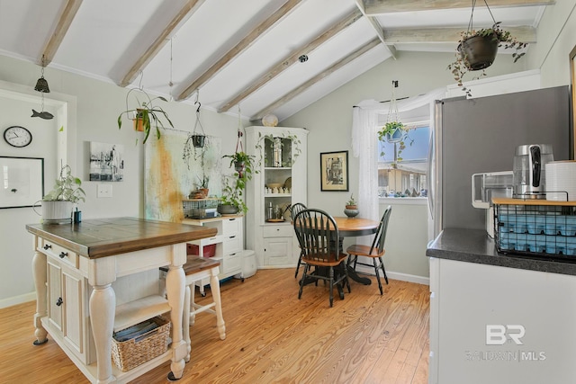 3425 Ponce De Leon Ct, Gulf Shores, AL 36542 - kitchen featuring dark countertops, vaulted ceiling with beams, baseboards, and light wood-style flooring