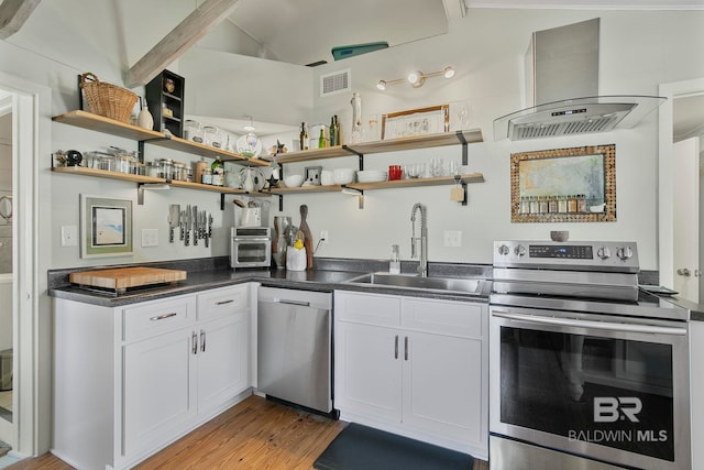 3425 Ponce De Leon Ct, Gulf Shores, AL 36542 - kitchen with visible vents, light wood-style floors, island range hood, a sink, and appliances with stainless steel finishes