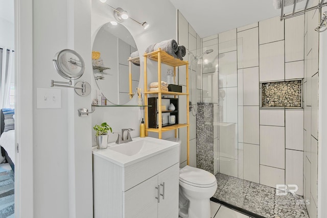 3425 Ponce De Leon Ct, Gulf Shores, AL 36542 - bathroom with vanity, tile patterned floors, a tile shower, and toilet