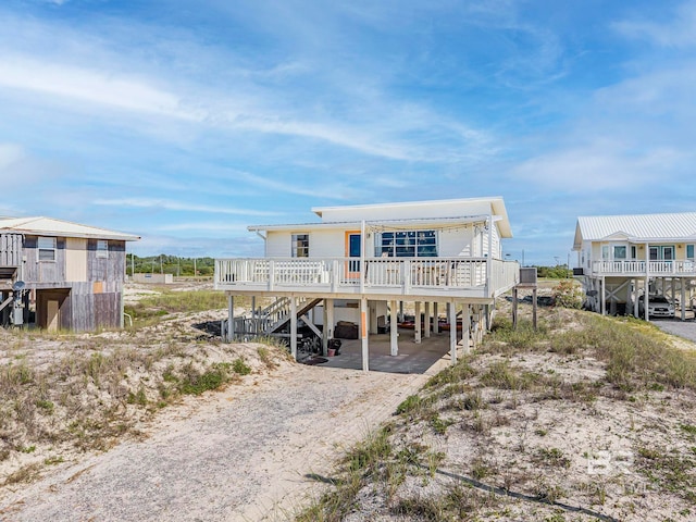 3425 Ponce De Leon Ct, Gulf Shores, AL 36542 - view of front of home featuring dirt driveway, a deck, stairway, and a carport
