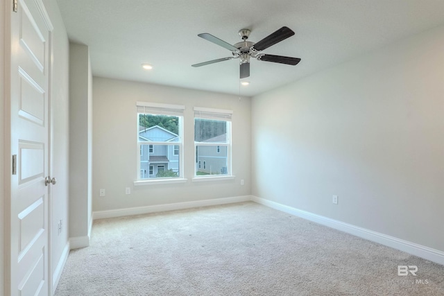 carpeted spare room featuring ceiling fan