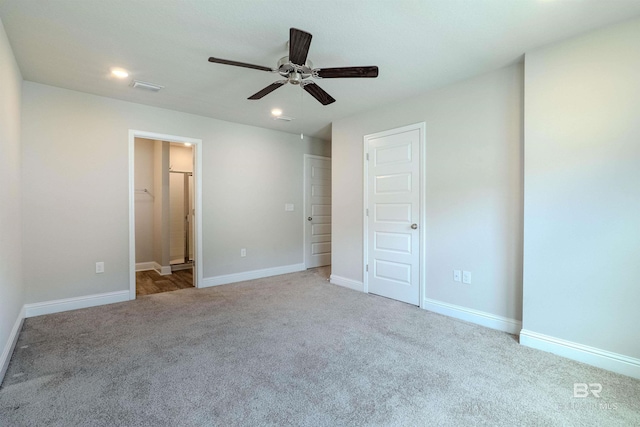 unfurnished bedroom featuring connected bathroom, ceiling fan, and light colored carpet