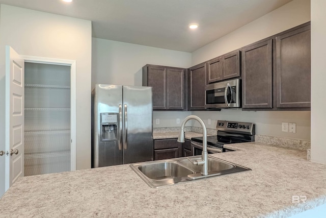 kitchen with dark brown cabinets, kitchen peninsula, sink, and stainless steel appliances