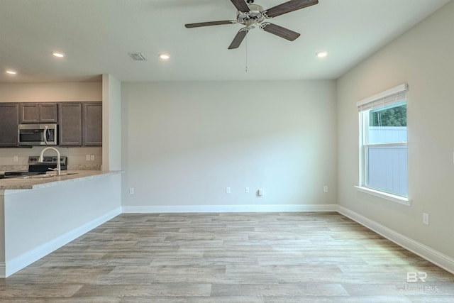 kitchen featuring light wood-type flooring, dark brown cabinetry, ceiling fan, and stainless steel appliances