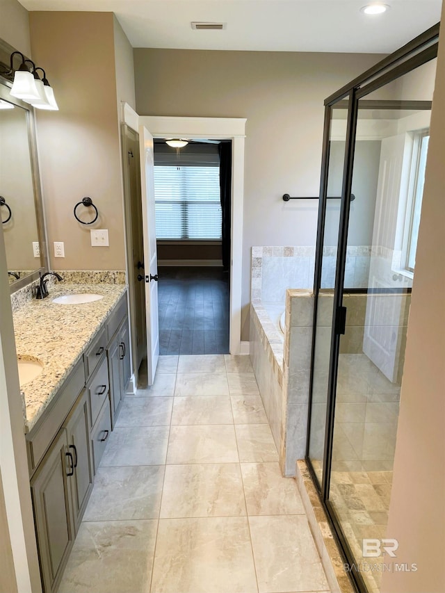 full bathroom with a sink, double vanity, visible vents, a stall shower, and a garden tub