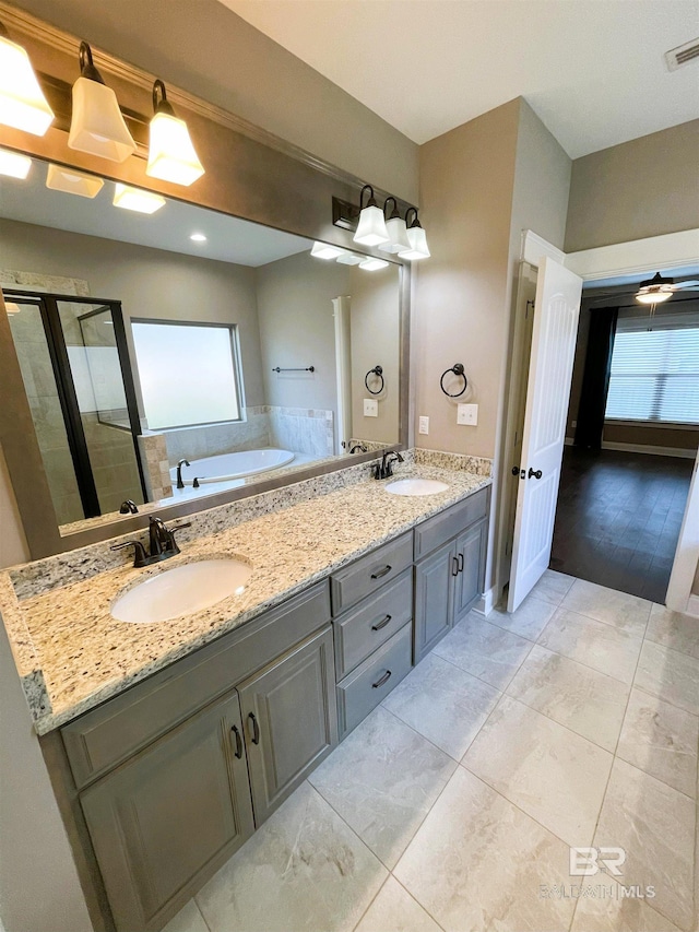 full bath with a stall shower, a sink, and plenty of natural light