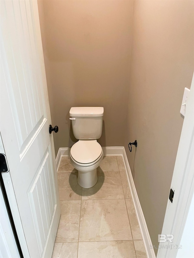 bathroom with toilet and baseboards