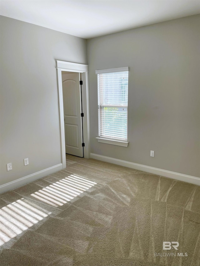 empty room featuring baseboards and carpet