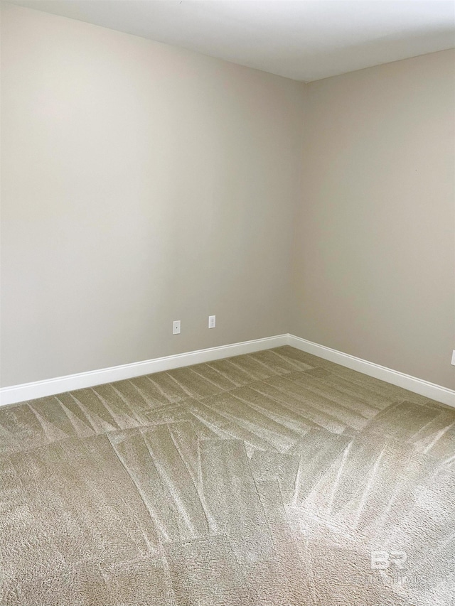 carpeted spare room featuring baseboards
