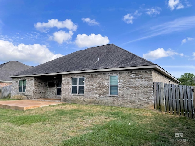 back of property featuring a patio, brick siding, fence, and a yard