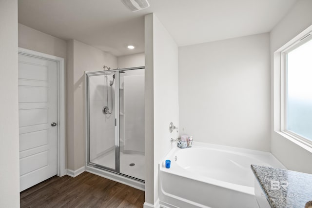 bathroom featuring plus walk in shower and hardwood / wood-style floors