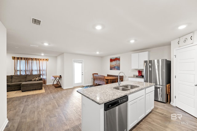 kitchen with white cabinets, sink, light hardwood / wood-style flooring, an island with sink, and appliances with stainless steel finishes