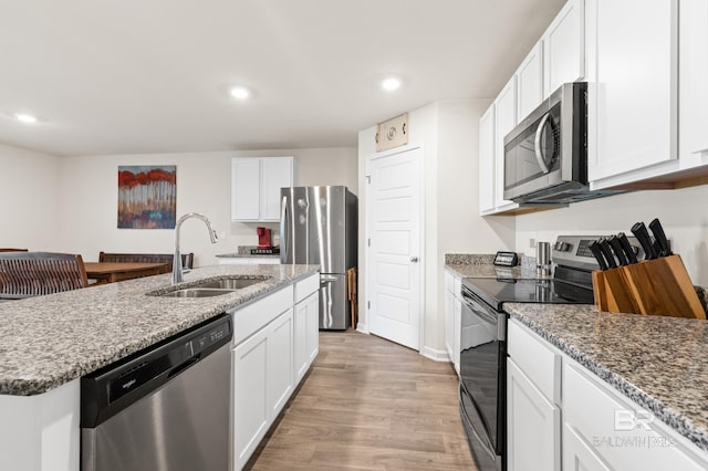 kitchen with white cabinetry, sink, stainless steel appliances, and light hardwood / wood-style floors