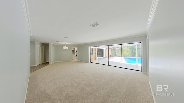 unfurnished room featuring ornamental molding, a chandelier, and light colored carpet