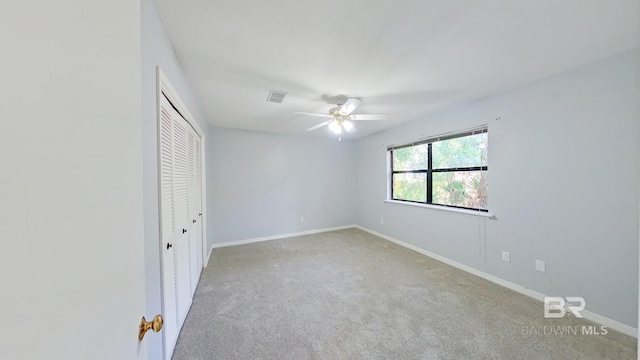 unfurnished bedroom with a closet, ceiling fan, and light carpet