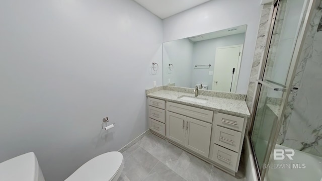 bathroom featuring a shower with door, toilet, and vanity