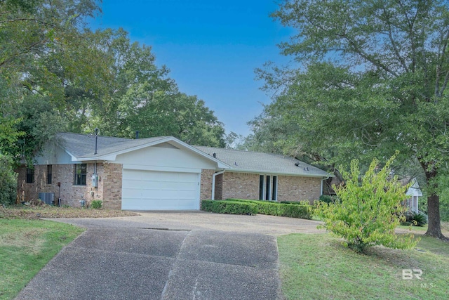 ranch-style home featuring a garage and central AC unit