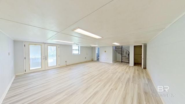 basement with french doors and light hardwood / wood-style floors