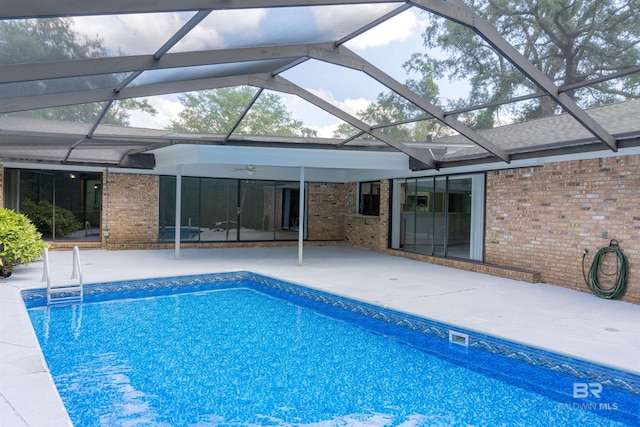 view of pool with a patio area and glass enclosure