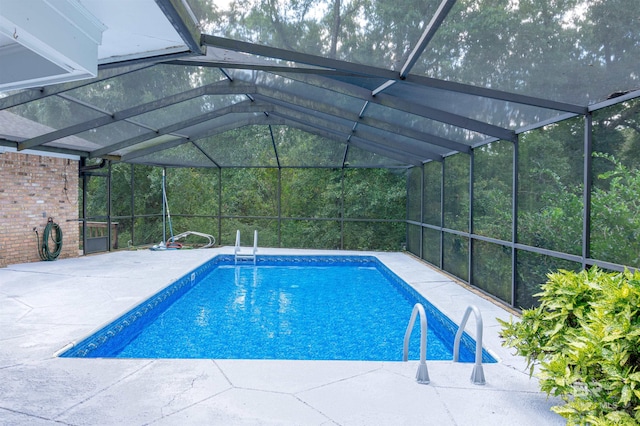 view of swimming pool featuring a patio area and a lanai