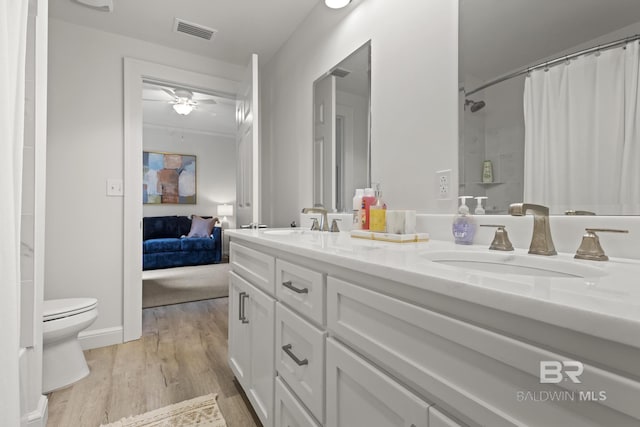 bathroom featuring toilet, hardwood / wood-style flooring, ceiling fan, a shower with curtain, and vanity