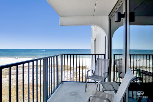 balcony featuring a beach view and a water view