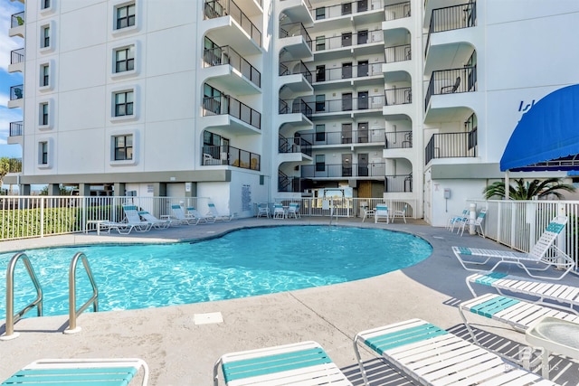 community pool with a sink, a patio area, and fence