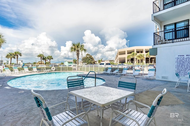 community pool featuring a patio and fence