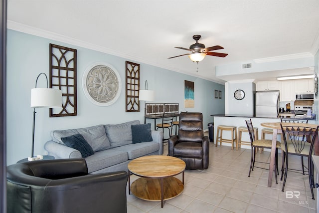 living area featuring light tile patterned flooring, a ceiling fan, visible vents, and ornamental molding