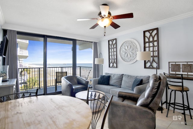 tiled living area featuring a textured ceiling, a ceiling fan, and ornamental molding