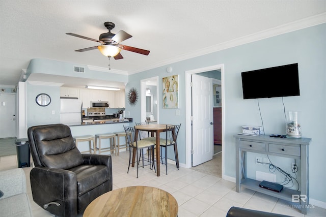 living area with visible vents, light tile patterned flooring, ornamental molding, ceiling fan, and a textured ceiling