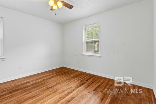 unfurnished room with baseboards, a ceiling fan, and light wood finished floors