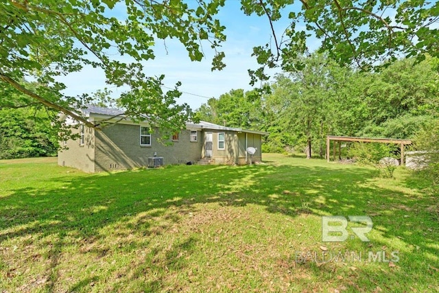 view of yard with central AC and entry steps